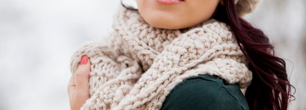 Woman holding scarf on neck outside in winter