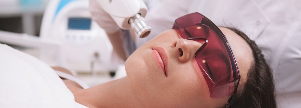 Woman receiving laser treatment with protective goggles on